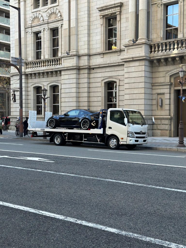 夜間にライトを灯して出動する積載車のイメージ
